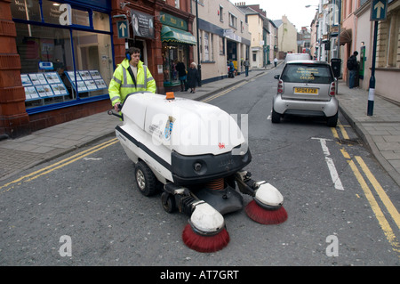 Des Rates Arbeiter, die Reinigung der Straßen von Aberystwyth mit einem lauten mechanischen Straße fegen Staubsauger Gehörschutz tragen Stockfoto