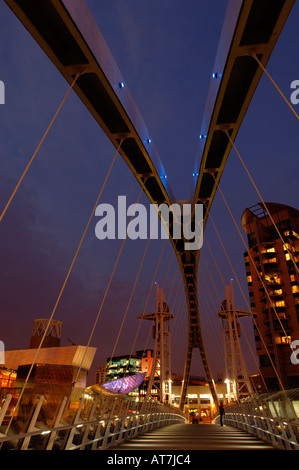 Manchester. Moderne Brücke überspannt einen Kanal an Salford Quays mit der Lowry Centre im Hintergrund. Stockfoto