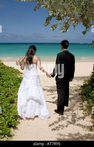 Braut und Bräutigam, türkisblaue Meer Strand Sand Weg hinunter wandern. Stockfoto