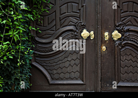 Alte geschnitzte Holztür mit poliertem Messing Griffe und Schlüsselloch Rothenburg Deutschland Stockfoto