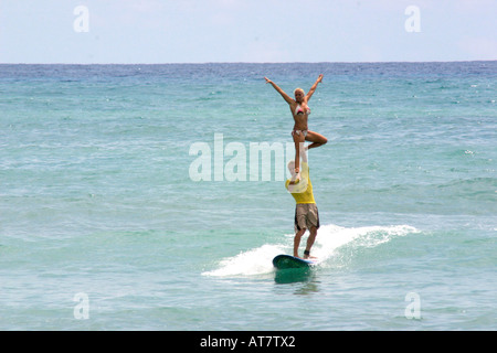 Tandem-Surfen, Mann Betrieb Frau über Kopf Stockfoto