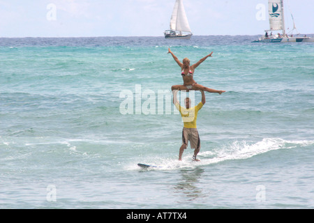 Tandem-Surfen, Mann Betrieb Frau über Kopf Stockfoto