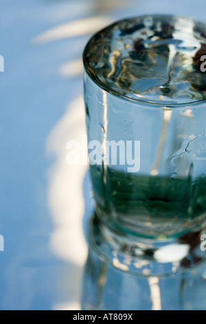 Wasser in ein Glas, das auf einem Spiegel steht Stockfoto