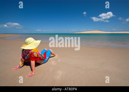 attraktive Frau sitzen auf roten Strand wrap Stockfoto