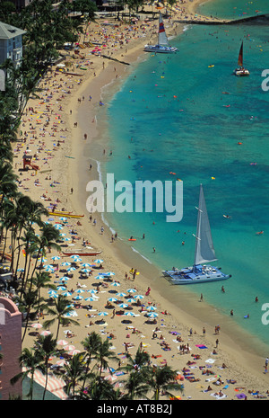 Lebendige Schuss von Waikiki Beach von der Spitze des Sheraton Hotels gesehen. Einen großen blauen und weißen Katamaran und Dutzende von blau Stockfoto