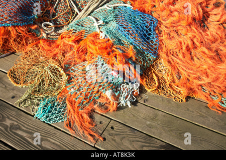 Bunte Fischernetze und Seil in der Sonne auf einer Holzterrasse. Stockfoto