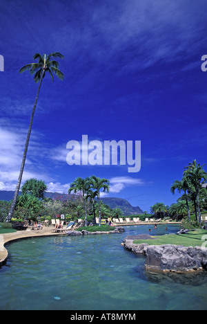 Menschen genießen Sie luxuriöse Pool mit Palmen & Bergen umrahmt von strahlend blauem Himmel. Hanalei Bay Resort, Kauais North shore Stockfoto