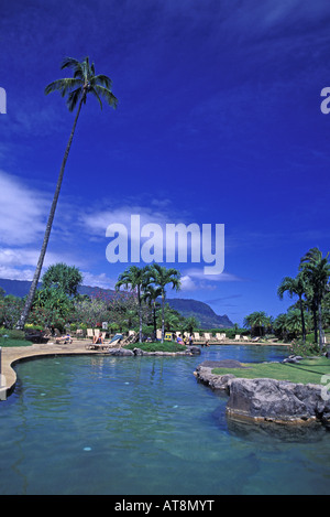 Menschen genießen Sie luxuriöse Pool mit Palmen & Bergen umrahmt von strahlend blauem Himmel. Hanalei Bay Resort, Kauais North shore Stockfoto