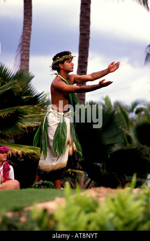 hübscher junger Hawaiian Mann, in einem traditionellen Hula Kostüm Ti Blätter und Tapa, schließt die Augen und erinnert an eine heilige Stimmung Stockfoto