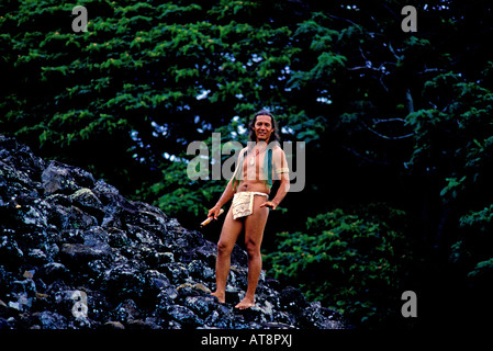 Eine attraktive lokale Mann trägt einen Lendenschurz steht neben Ulupo Heiau in der Nähe von Kailua auf der windzugewandten Seite von Oahu. Stockfoto