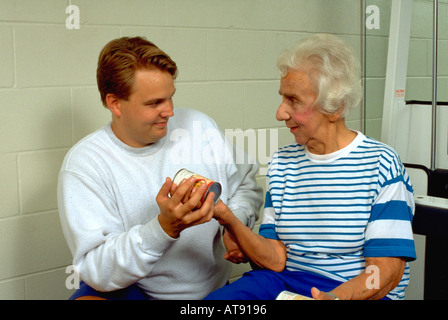 Trainer Alter 25 mit Alter Frau 80 mit Suppe Gewichte Lynnwood Recreation Center können. St Paul Minnesota MN USA Stockfoto