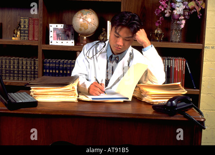 Koreanische amerikanische Arzt Intern Arzt Alter 24 arbeiten am Schreibtisch. St Paul Minnesota MN USA Stockfoto