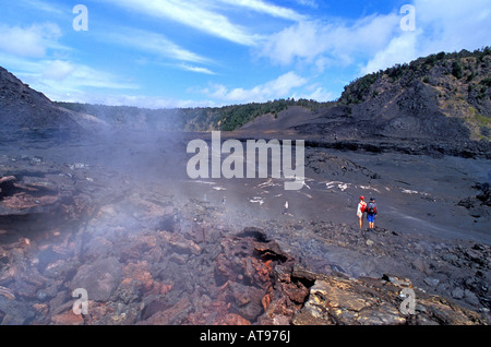 Zwei Wanderer Fuß in dampfenden, desolate Kilauea Iki Crater im Volcanoes National Park auf der Big Island von Hawaii Stockfoto