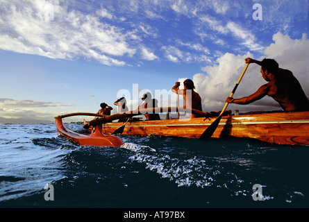 Paddler in einem Koa Kanu vor Waikiki Beach an einem schönen Nachmittag, fotografiert vom Wasserstand. Stockfoto