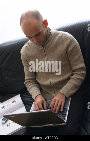 Geschäftsmann mit Notebook auf einer Couch sitzen Stockfoto