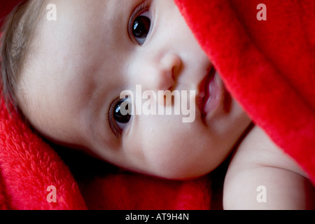 Baby Mädchen 4-6 Monate in eine rote Decke von einem kaukasischen Vater und indonesische Mutter Stockfoto