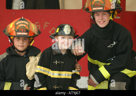 3 zukünftige Feuerwehrleute in Uniform auf einem Feuer Sicherheit Messe Stockfoto