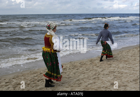 Zwei Frauen einer Tracht-Gruppe zu Fuß an einem Strand in Miedzyzdroje, Polen Stockfoto