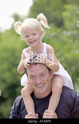 Glückliches Mädchen reitet auf Papa Huckepack Stockfoto