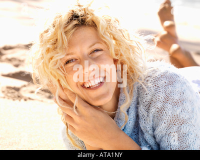 Porträt von attraktiven jungen Frau liegend im Sand auf Maui Hawaii Strand lächelnd hautnah Stockfoto