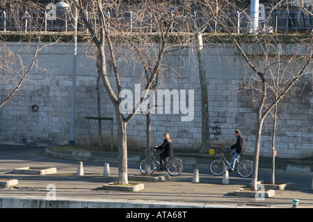Ein französisches Ehepaar, Radfahren entlang der Seine auf Vélib-Bikes. Vélib ist eine öffentliche Fahrrad Vermietung Schema in Paris, Frankreich Stockfoto