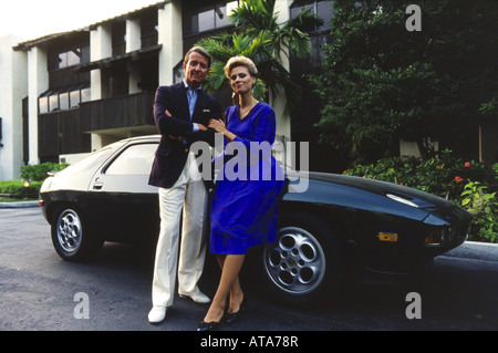 Elegante Paar mit Porshe Sportwagen außerhalb der Wohnung.  Porträt, Miami Stockfoto