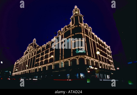 Das Kaufhaus Harrods mit Lichtern beleuchtet bei Nacht London England Stockfoto