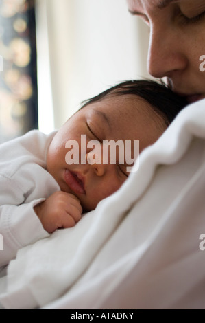 Neugeborenes Babymädchen schläft auf Mutters Schulter Stockfoto