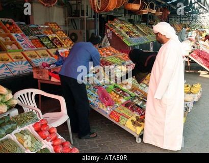 Ein arabisches paar shopping für Obst und Gemüse an einem Marktstand, Stadt Abu Dhabi, Vereinigte Arabische Emirate Stockfoto