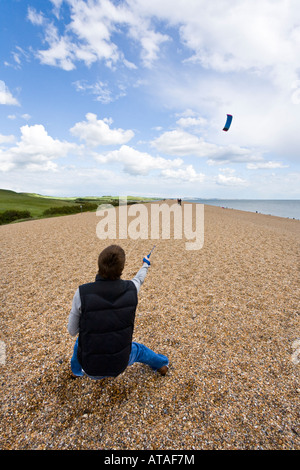 Ein Jüngling ein macht-Drachen auf Chesil Beach, Dorset Stockfoto