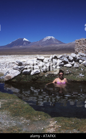 Hispanic Frau genießen die heißen Quellen, Payachatas Vulkane im Hintergrund, Nationalpark Sajama, Bolivien Stockfoto