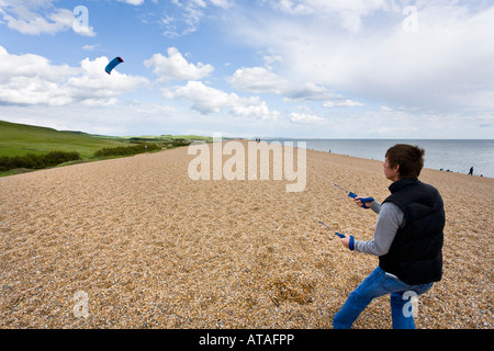 Ein Jüngling ein macht-Drachen auf Chesil Beach, Dorset Stockfoto