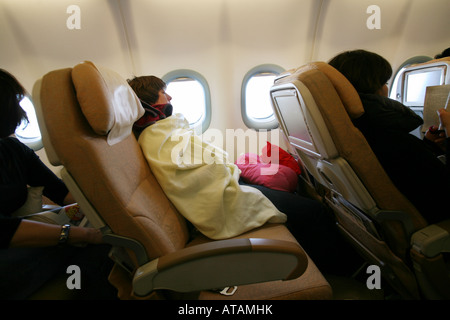 Eine Frau Fluggast in einer zurückgelehnten Sitz schlafen auf einem Langstreckenflug; Etihad Airline Stockfoto