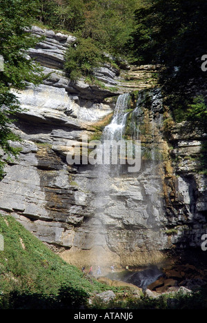 Wanderer zu Fuß hinter dem Grand Saut Wasserfall über den l'Eventail fällt bei der Cascades de Hérisson im französischen Jura Stockfoto