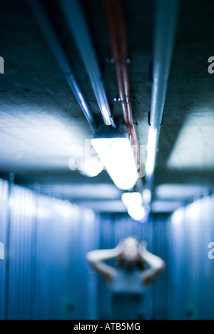 Frau posiert in einem beleuchteten Flur in einem Keller Stockfoto