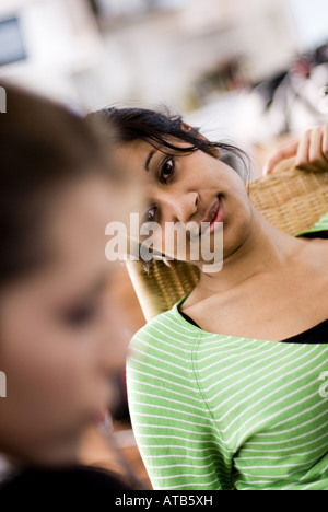 Darkhaired junge Frau mit unglücklichen Blick, ihre Freundin im Vordergrund unscharf Stockfoto