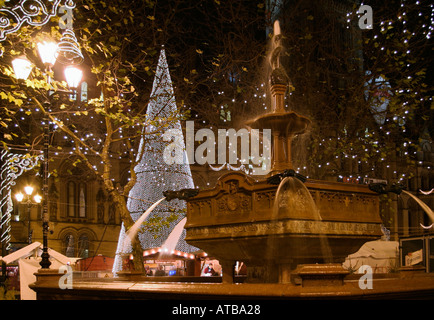 Weihnachten in Albert Square, Manchester. Ein Weihnachtsbaum und die Victoria Jubiläum Brunnen. Stockfoto