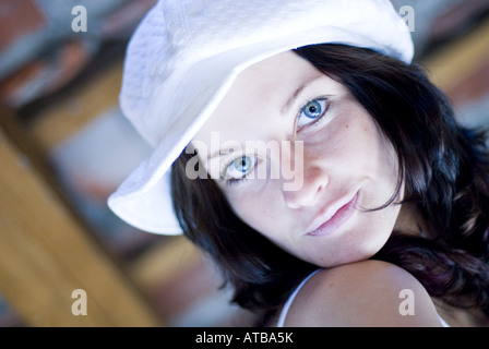 niedliche dunkelhaarige Frau mit Fashinable Kappe Stockfoto