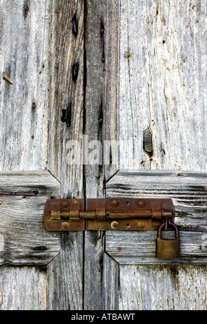 Alte Holztür mit einem rostigen Vorhängeschloss Stockfoto
