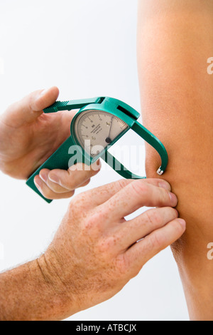 Nahaufnahme eines erwachsenen männlichen Hand mit Bremssattel um Körperfett zu testen Stockfoto