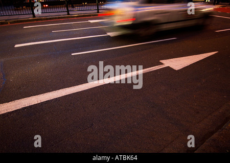 Weiße Straßenpfeile zeigen die Geschwindigkeit des vorbeifahrenden Verkehrs an Stockfoto