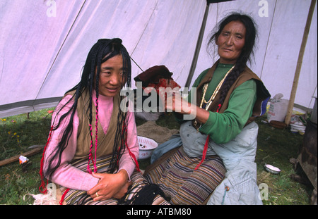 Khampa Frau Flechten ihr Haar in 108 Stränge-ein glücklicher tibetischen Reihe in Lithang Pferdefest. Sichuan, China Stockfoto