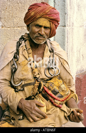 Anhänger-Gesicht verschmiert mit gelben Kurkuma Pulver und Heavy Metal Kette um Hals Jejuri Maharashtra, Indien Stockfoto