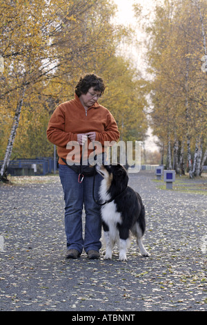 Australian Shepherd (Canis Lupus F. Familiaris), Frau training und Wandern mit Hund Stockfoto