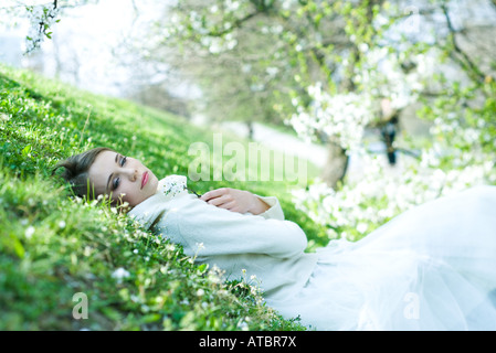 Teenager-Mädchen auf den Boden, halten Blume, halb geöffneten Augen liegen Stockfoto