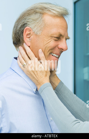 Reifer Mann mit Frau die Hände auf sein Gesicht, beschnitten, Ansicht Stockfoto
