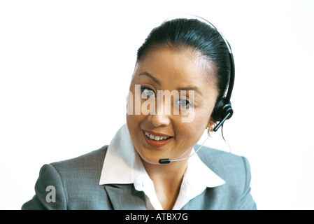 Geschäftsfrau tragen Kopfhörer, lächelnd in die Kamera, Nahaufnahme Stockfoto