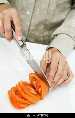 Schneiden von Tomaten mit Messer, Frau beschnitten Ansicht Stockfoto