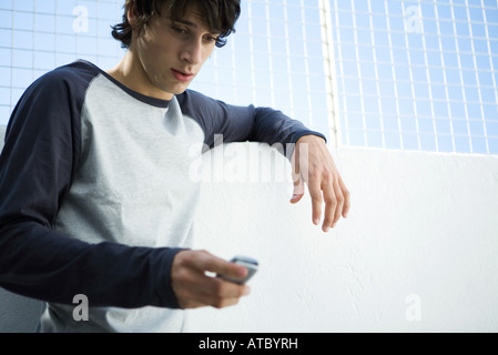 Junger Mann blickte auf Handy, Nahaufnahme Stockfoto