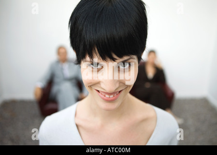 Frau lächelt in die Kamera, eine Augenbraue hob, Nahaufnahme Stockfoto